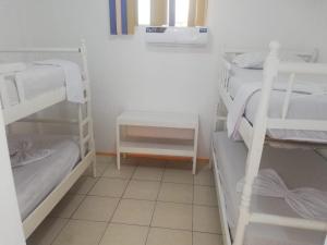 a room with two bunk beds and a tiled floor at Hotel Carmita in Atacames
