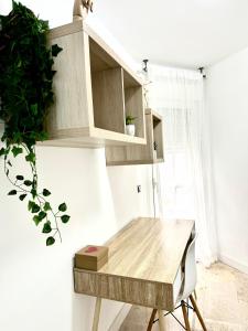 kuchnia z drewnianym stołem i rośliną w obiekcie Alojamiento Bruckner w Maladze