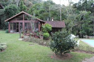 een klein huis met een tuin en een zwembad bij Casa do Fachoalto in Petrópolis