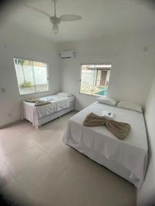 1 dormitorio con 2 camas y 2 ventanas en Anexo Canadense - Pousada Mineira SJB, en São João da Barra