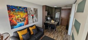 una sala de estar con sofá y una pintura en la pared en Best Apartment Rental Estación Central, en Santiago