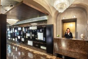 a woman standing at a counter in a hotel lobby at The Style in Rome