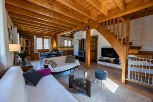 sala de estar con sofá blanco y techo de madera en Parenthèse Alpine - Barbecue - Terrasse - Parking, en Enchastrayes