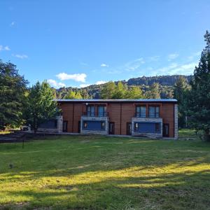 a building with a grass field in front of it at ANFITEATRO APARTS & LOFTS in San Carlos de Bariloche