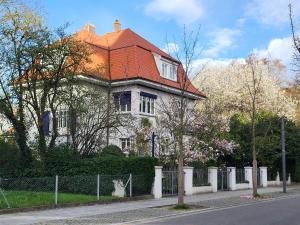 a house with a red roof on a street at Villa Am Rosenfelspark in Lörrach