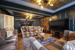 a living room with two couches and a television at Luxury 8 Bed Manor House Hot Tub Cinema Room SkyTV in Saffron Walden