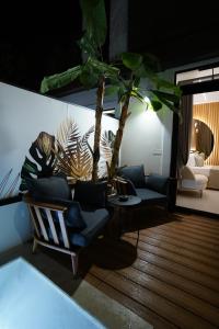 een woonkamer met een bank en een palmboom bij Barneys B&b in Cercola