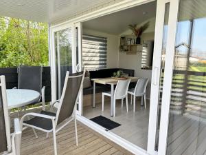 a screened in porch with a table and chairs at Chalet 1a op Recreatiepark De Wielen in Sint Maarten