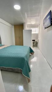 um quarto com uma cama verde num quarto em Apartaestudios White And Grey em Popayán