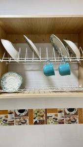 uma prateleira com pratos e utensílios numa máquina de lavar louça em Apartaestudios White And Grey em Popayán