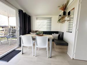 a kitchen and dining room with a table and chairs at Chalet 1a op Recreatiepark De Wielen in Sint Maarten +11 photos