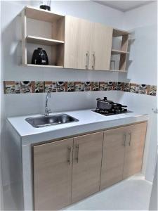 uma cozinha com um lavatório e um fogão em Apartaestudios White And Grey em Popayán