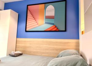 een slaapkamer met een spiegel aan een blauwe muur bij Dante Riviera in Nice
