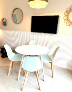 ニースにあるDante Rivieraのテレビ付きの客室で、テーブルと椅子が備わります。