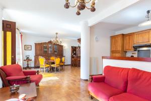 Magliano Alfieri的住宿－Casa Daniel - casa con giardino，客厅配有红色的沙发和桌子