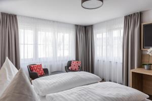 um quarto com uma cama, 2 cadeiras e janelas em Gasthof Zum Roten Haus 