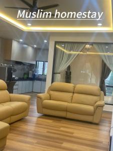 ein Wohnzimmer mit 2 Sofas und einer Küche in der Unterkunft Adik aisyah teres golden hill Cameron Highlands in Brinchang