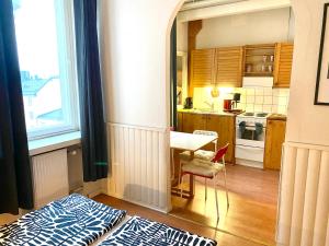 una pequeña cocina con mesa y ventana en Small home in Kamppi en Helsinki