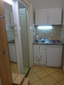 Una pequeña cocina con gabinetes blancos y un fregadero. en M Apartments - Downtown, en Budapest 14 fotos más