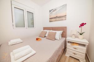 ein weißes Schlafzimmer mit einem Bett und einem Fenster in der Unterkunft Apartment Rosemary - Happy Rentals in Herceg-Novi