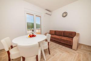 ein Wohnzimmer mit einem Tisch und einem Sofa in der Unterkunft Apartment Rosemary - Happy Rentals in Herceg-Novi