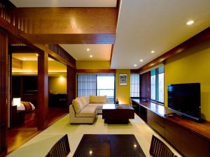 un soggiorno con divano e TV di 竹泉荘 Chikusenso Onsen a Zao