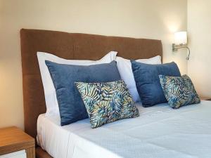 a bed with blue and white pillows on it at Albufeira Sol Villas V - Pool and Garden & Gym & SPA in Albufeira