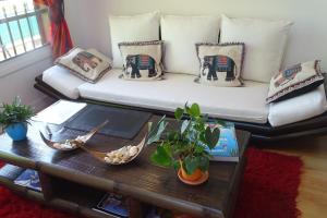 salon z kanapą z poduszkami i stołem w obiekcie La bambouseraie w mieście Montrouge