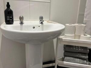 uma casa de banho com um lavatório branco e um espelho. em Manchester flat close to City Centre and Stadium em Manchester