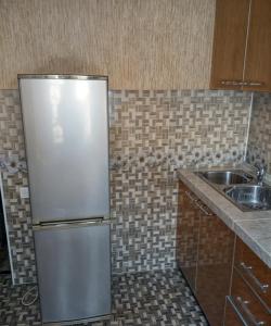 a kitchen with a stainless steel refrigerator and a sink at Apartment near the airport - Квартира около аэропорта in Dushanbe