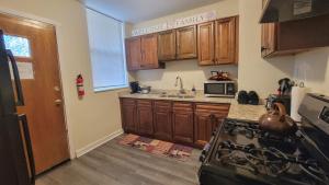 a kitchen with wooden cabinets and a stove top oven at Chateau de Woodlawn - Room II - Le Parisienne in Chicago
