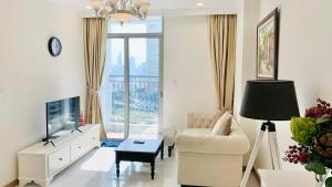 - un salon avec un canapé et une télévision dans l'établissement Căn hộ Vinhomes Central Park- CityLights Premium Apartment, à Hô-Chi-Minh-Ville