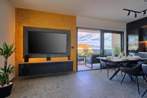 a living room with a large television on a wall at Vice's Place - Sea-View & Pool in Slatine