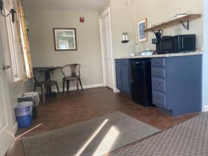 une cuisine avec un meuble bleu et une table dans l'établissement The Wildflower Inn, à Lyndonville