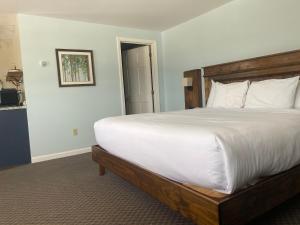 a bedroom with a large bed with white sheets at The Wildflower Inn in Lyndonville