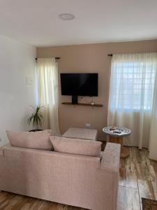 a living room with a couch and a flat screen tv at Departamento Navarro in Malargüe