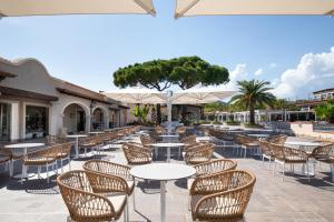 an outdoor patio with tables and chairs and umbrellas at Tanka Selected in Villasimius