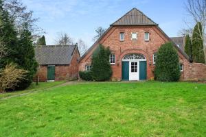 una casa in mattoni con una porta verde e un cortile di Galerie Haus Wohnung 4 a Sehestedt