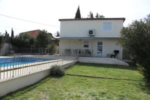 a white house with a swimming pool in a yard at Chez Claudia et Serge in Vernègues
