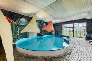 a large swimming pool in a tent with a tub at Galerie Haus Wohnung 3 in Sehestedt