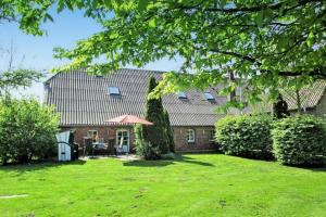 a house with a green yard in front of it at Galerie Haus Wohnung 3 in Sehestedt