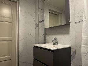 uma casa de banho com um lavatório e um espelho em Spacious Studio Apartment em Estocolmo