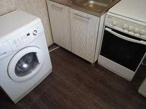 eine Küche mit einer Waschmaschine und einem Waschbecken in der Unterkunft Апартаменты посуточно по Ауэзова in Öskemen