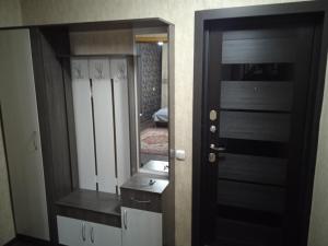 ein Bad mit einem Spiegel und einer schwarzen Tür in der Unterkunft Апартаменты посуточно по Ауэзова in Öskemen