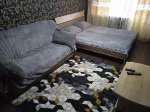 ein Bett und ein Sofa in einem Zimmer in der Unterkunft Апартаменты посуточно по Ауэзова in Öskemen