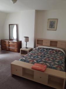 - une chambre avec un lit, une commode et un miroir dans l'établissement Pleasant Rooming House, à Washington