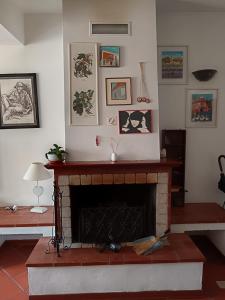 a living room with a fireplace with pictures on the wall at Da Carlotta in Castel di Sangro