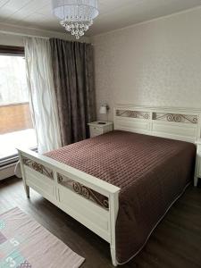 een wit bed in een slaapkamer met een raam bij Villa Rauhan Helmi in Lappeenranta