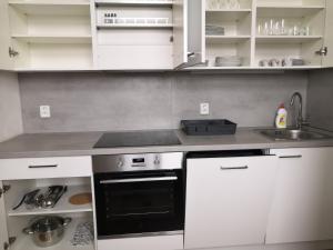 a kitchen with white cabinets and a black oven at Brand new apartments and hostel in center in Prague