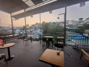 a restaurant with tables and chairs on a balcony at DALAT INN PEACEFUL in Da Lat